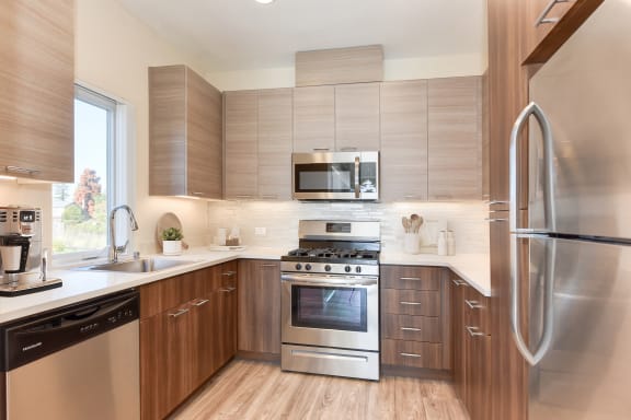 a kitchen with stainless steel appliances and wooden cabinets  at Addison Ranch Apartments, Petaluma, CA