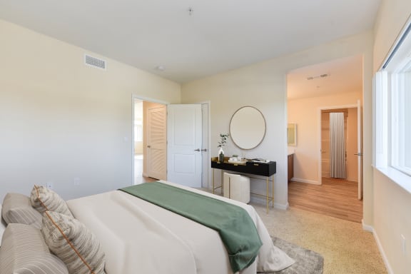 a bedroom with a large bed and a desk with a mirror  at Addison Ranch Apartments, Petaluma, CA