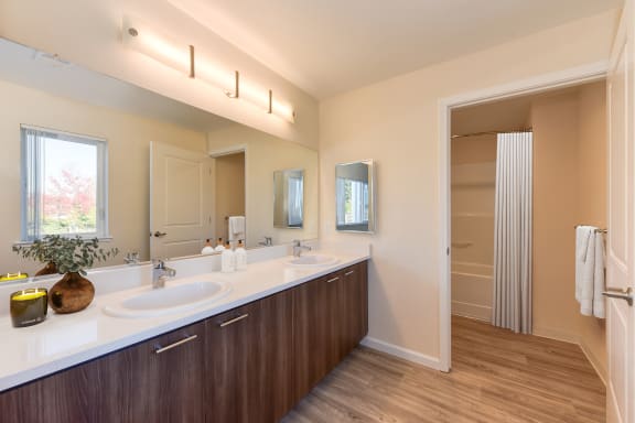 a bathroom with two sinks and a large mirror  at Addison Ranch Apartments, Petaluma, CA