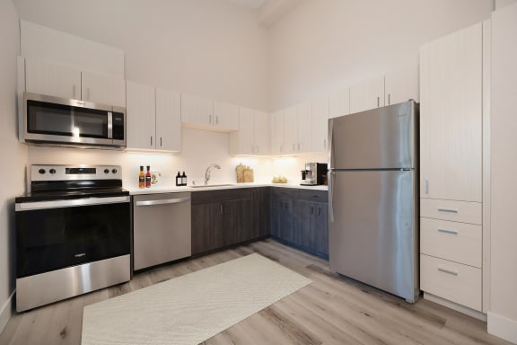 a modern kitchen with stainless steel appliances and white cabinets at Track 281 Apartments, California, 95811
