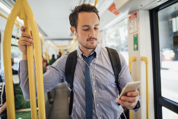young male in dress shirt and tie on the city bus while on his cell phone. at The Retreat at Walnut Creek, Walnut Creek, 94596