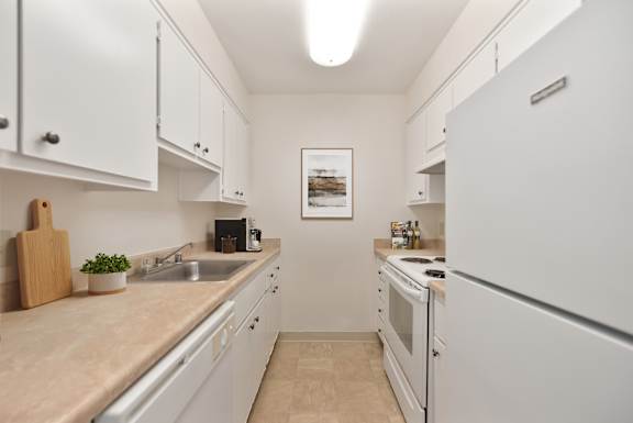 A kitchen with white cabinets and a beige countertop.