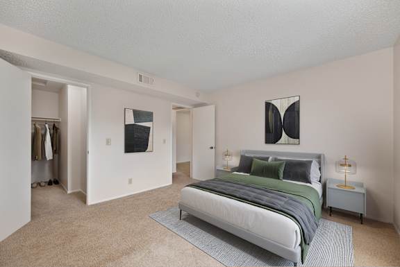A bedroom with a large bed and two nightstands.