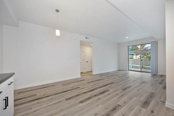 A room with a wooden floor and a white wall.