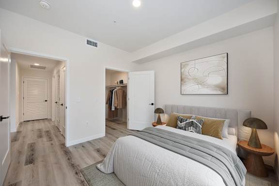 A bedroom with a large bed and a painting on the wall.