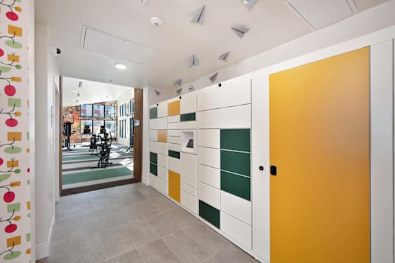 A hallway with a yellow door and a white wall with a pattern of squares and rectangles.