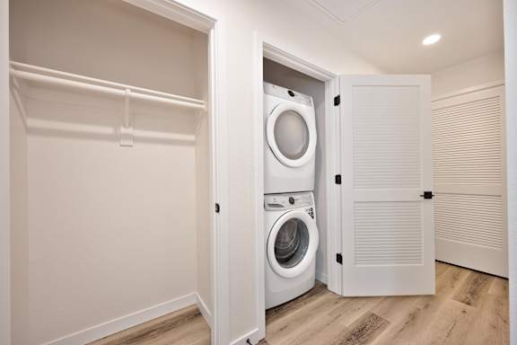 A white washing machine is in a small laundry room.
