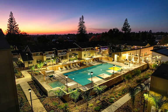A pool surrounded by a residential area at dusk.