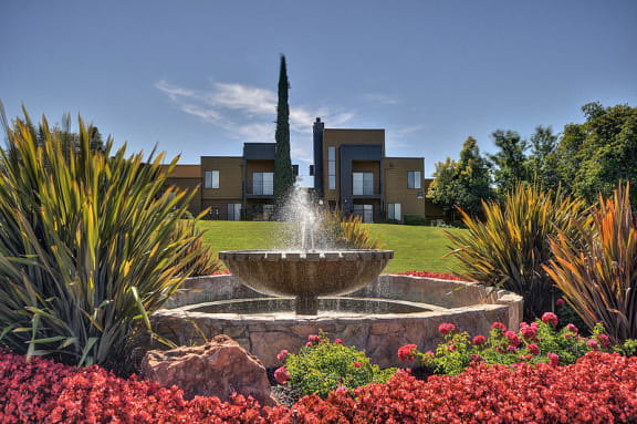 Community Outdoor Green Space with Stone Fountain, Flower Bed, Plants, Apartment Exteriors at Fountains of Fair Oaks, California, 95628