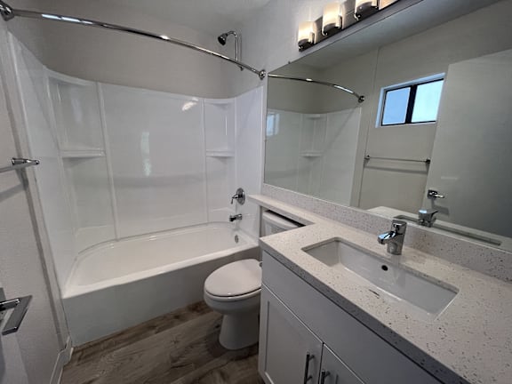 A white toilet sits in a bathroom next to a sink.
