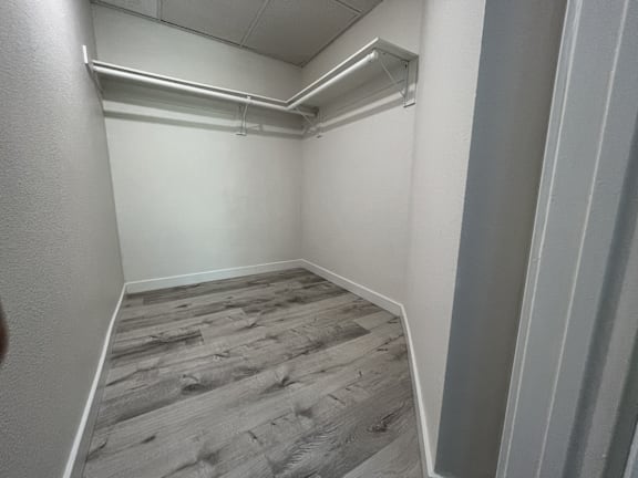 A room with wooden flooring and white walls.