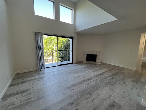 A spacious room with a fireplace and sliding glass doors.