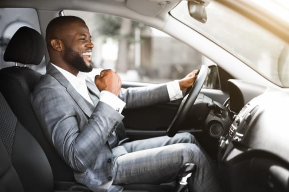 Business professional male in gray suit excited while driving car.at Folsom Ranch, California
