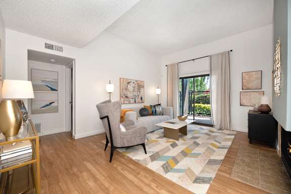 a living room with a couch and chairs and a sliding glass door at Fountains of Fair Oaks, Fair Oaks