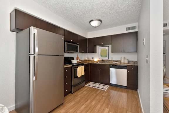 full kitchen with stainless steel appliances and wooden flooring in an apartment at Fountains of Fair Oaks, Fair Oaks, CA