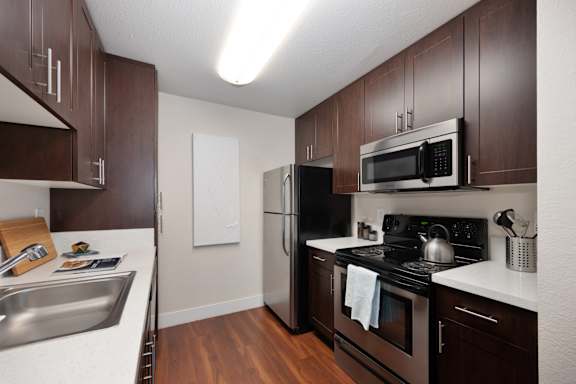 A kitchen with dark wood cabinets and stainless steel appliances at Folsom Ranch, Folsom, CA, 95630