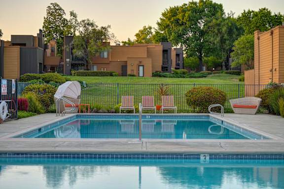 A pool surrounded by a fence and chairs at Fountains of Fair Oaks, Fair Oaks