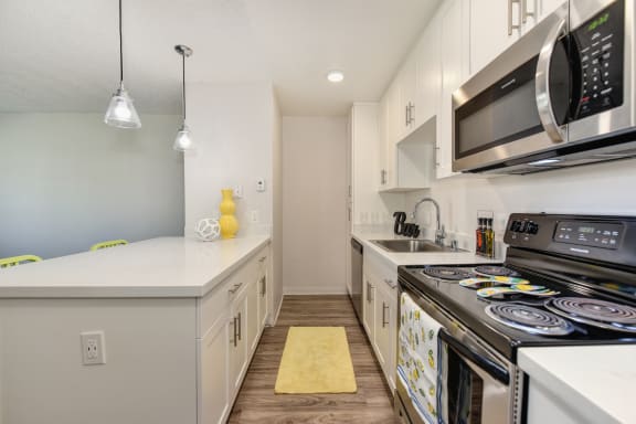 2x1 floor plan kitchen area with electric stove, oven, microwave and dishwasher. at Pinecrest Apartments, Davis, CA, 95616