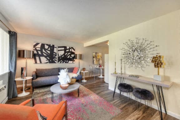 The Douglas floor plan living Room with Hardwood Inspired Floors, Orange Chairs and Window  at Olympus Park Apartments, California, 95661
