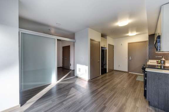 A modern kitchen with a wooden floor and a glass door.