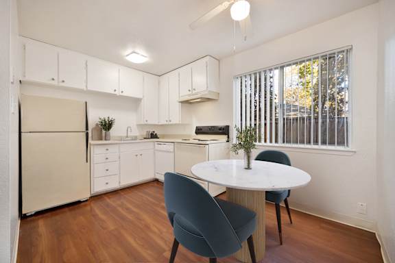 A kitchen with a table and chairs. at Olympus Park Apartments, California, 95661