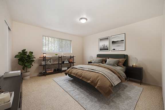 A bedroom with a bed, nightstand, and a plant at Olympus Park Apartments, Roseville, California