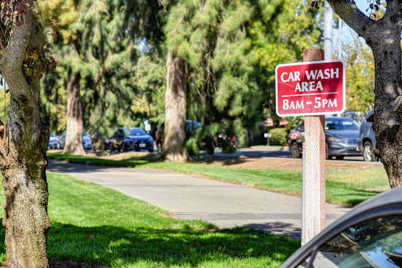 A sign in a park that says Car Wash Area 8am-5pm.