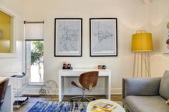 A living room with a white desk and a chair.