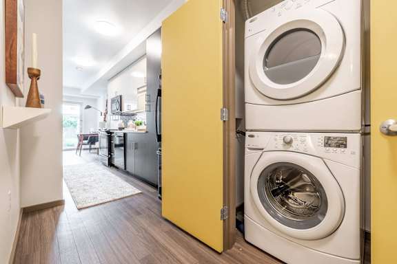 A washing machine is in a yellow door at Rivet Apartments, Seattle, WA