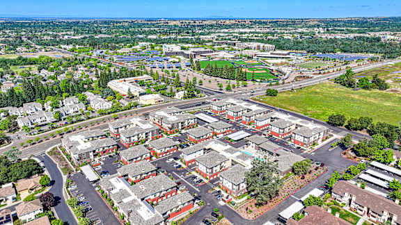 A bird's eye view of a residential area with multiple houses and a road.