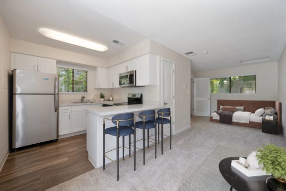 a kitchen with a bar with three stools at Silverstone Apartments, California