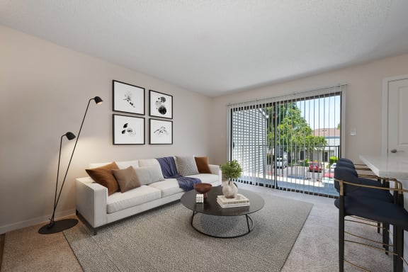 an open living room with a couch and a coffee table   and a balcony at Silverstone Apartments, Davis, CA, 95618