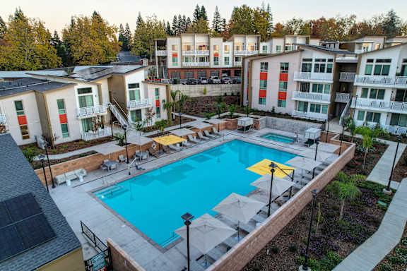 A swimming pool surrounded by apartment buildings and trees.