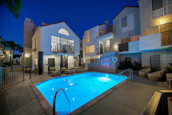 A swimming pool in a backyard surrounded by a fence.