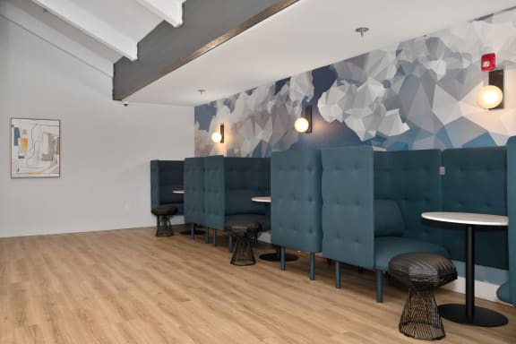 a room with blue couches and stools and a wall with a geometric design  at Track 281 Apartments, Sacramento, CA
