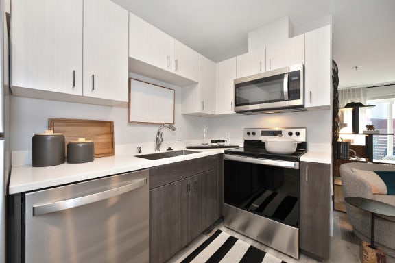 a modern kitchen with stainless steel appliances and white cabinets  at Track 281 Apartments, California, 95811