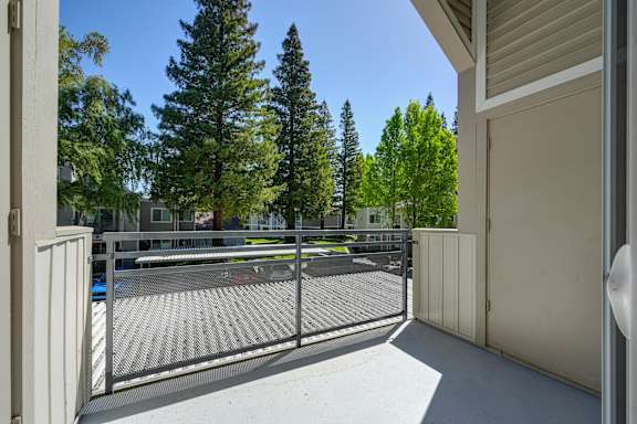 the view of a tennis court from a balcony with a fence