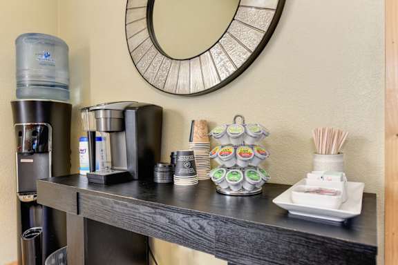 A bathroom counter with a mirror, toiletries, and a candle.