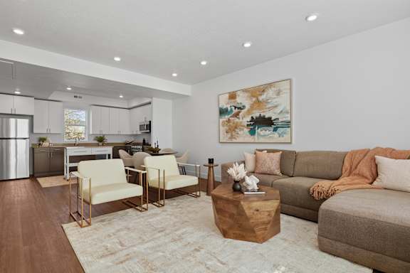 A living room with a brown sofa, a coffee table, and a painting on the wall.