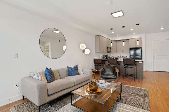 A modern living room with a grey couch and a coffee table.