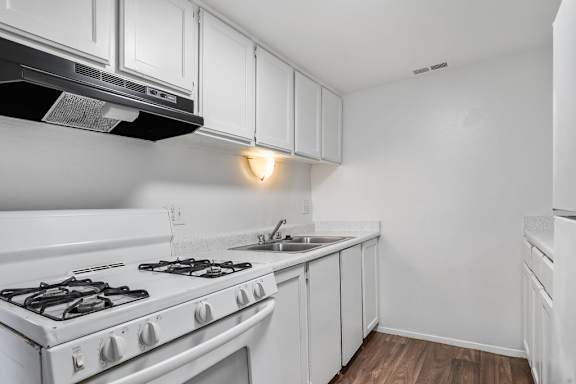 A white kitchen with a stove and cabinets.