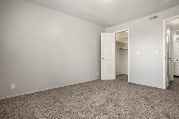 A room with a carpeted floor and a white door.