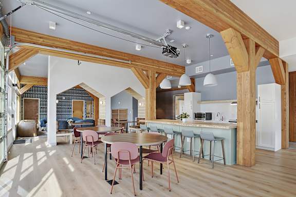 A kitchen with a dining table and chairs.