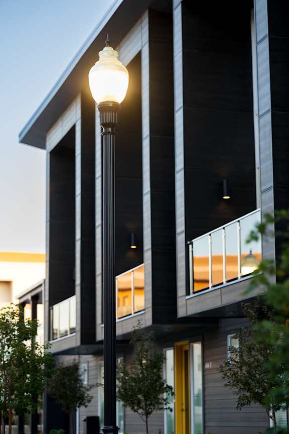 A street lamp is lit up in front of a building.