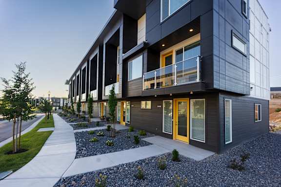 A modern building with a balcony and glass doors.