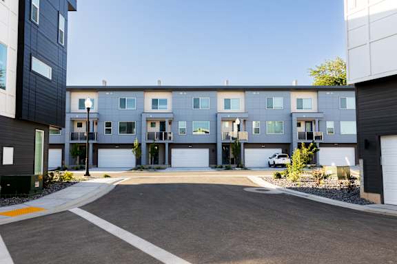 A modern apartment complex with a parking lot in front.