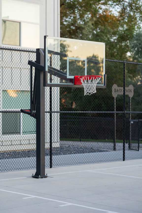 A basketball hoop is mounted on a stand in a basketball court.
