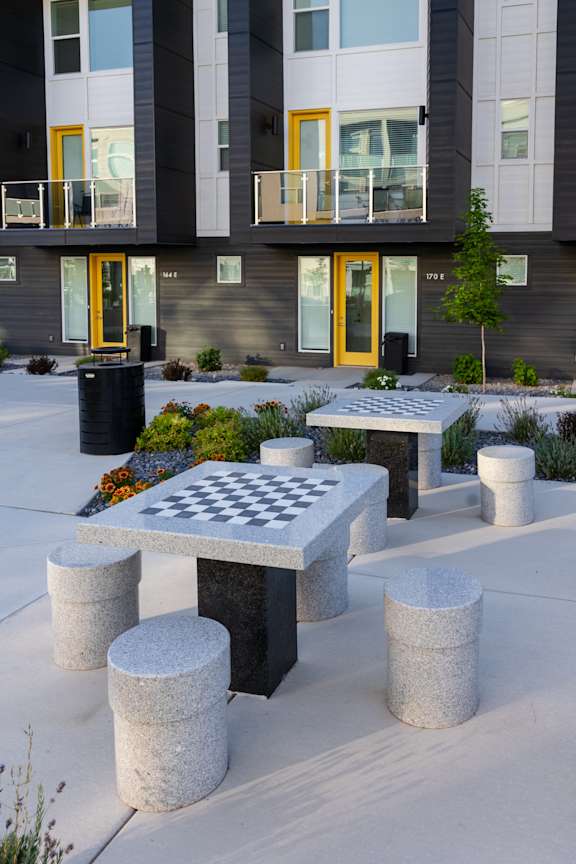 A chess board is set up on a table outside a building.