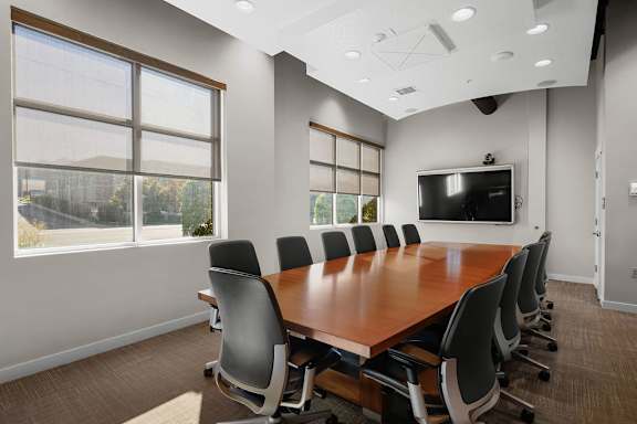 A conference room with a long table and chairs.
