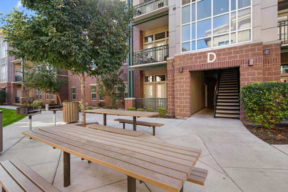 A wooden bench is in front of a building with a glass window.